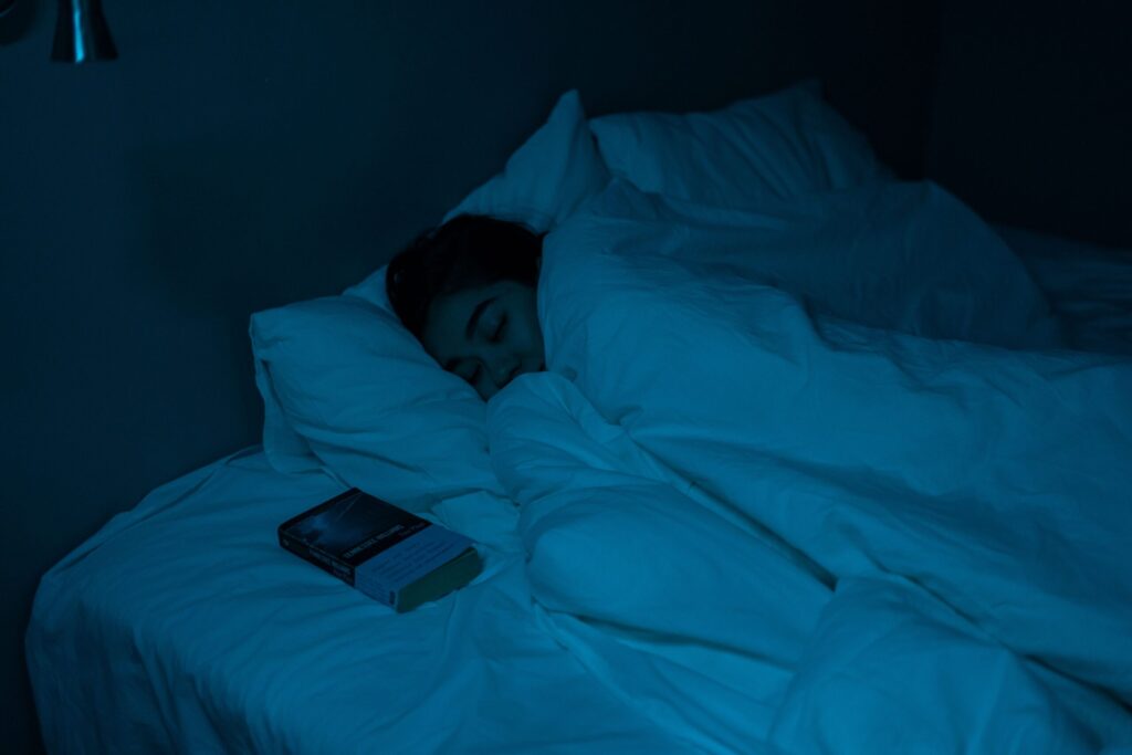 暗い寝室のベッドで眠る人