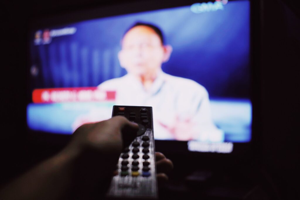 テレビのリモコンを持つ手