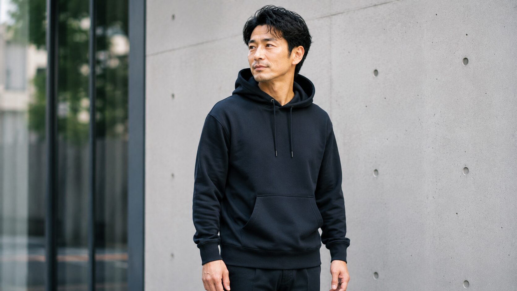 ジャストサイズの黒パーカーを着た男性