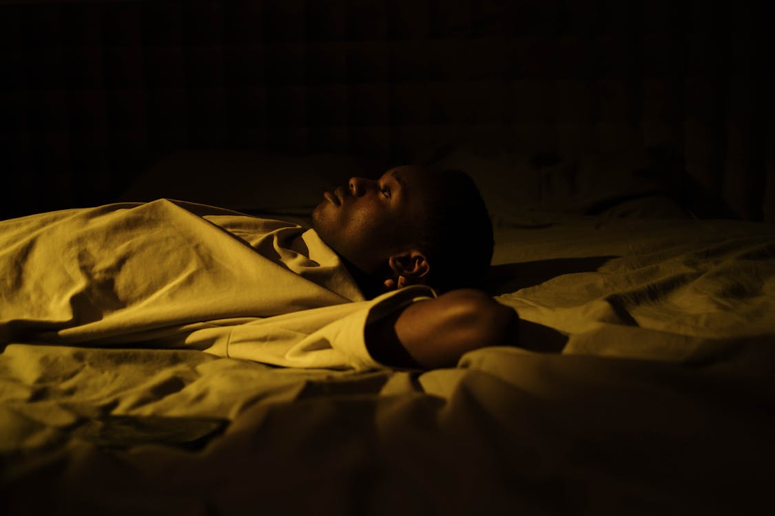 ベッドで眠れず悩む男性