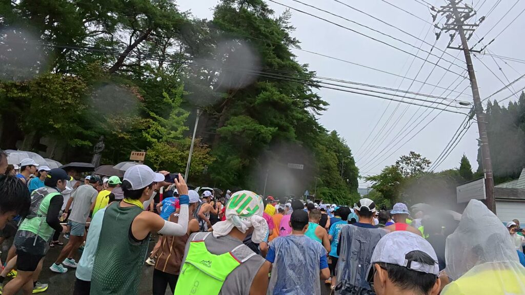 雨の中、スタートしたばかりのランナーの集団
