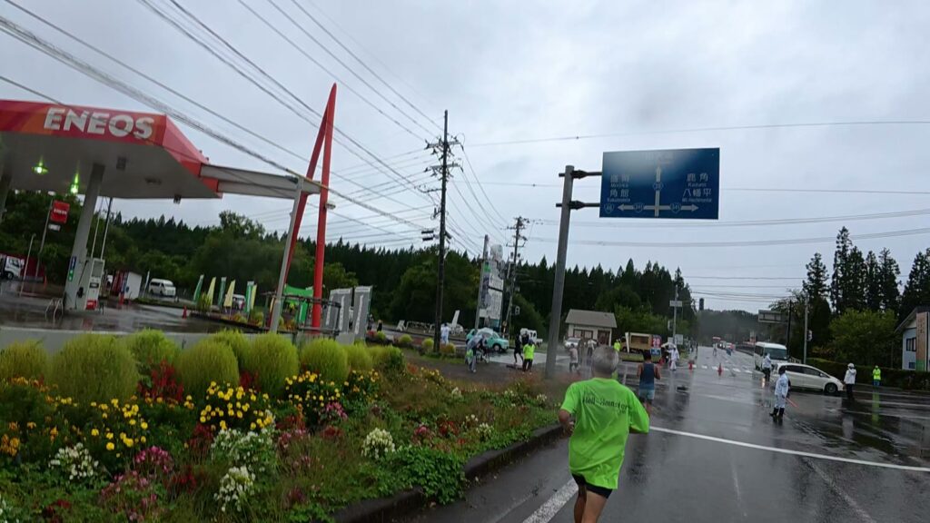 ガソリンスタンドのある交差点を通過するランナー(7km付近)