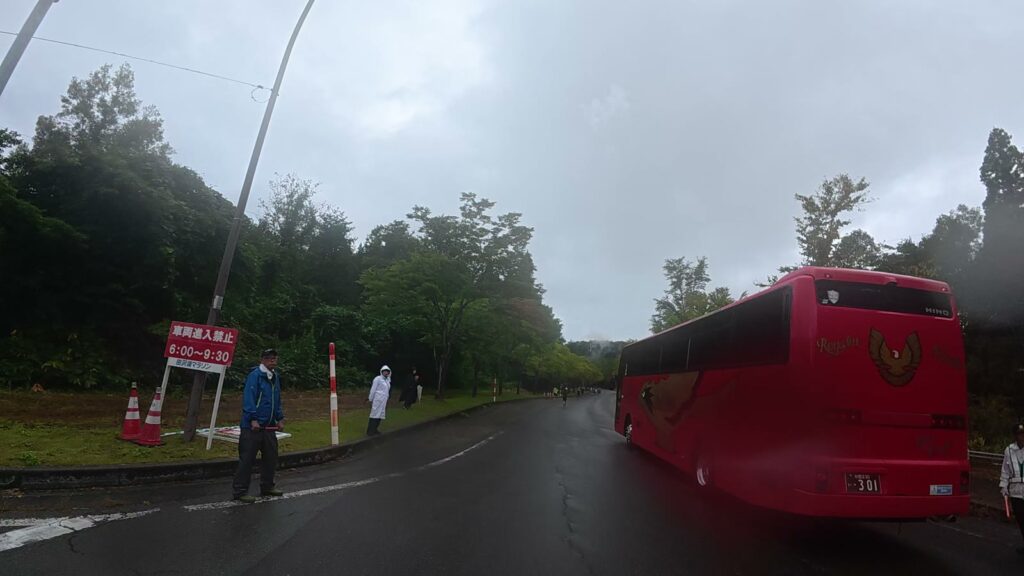 交通整理が行われている交差点と赤いバス(21.4km付近)