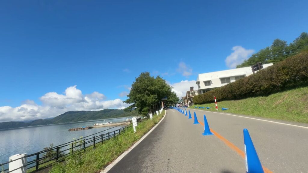 晴れて青く光る田沢湖とゴール手前の湖畔の道