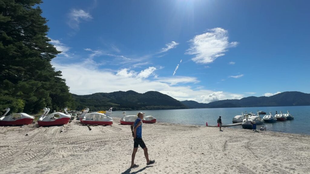 青空の下の田沢湖と浜辺