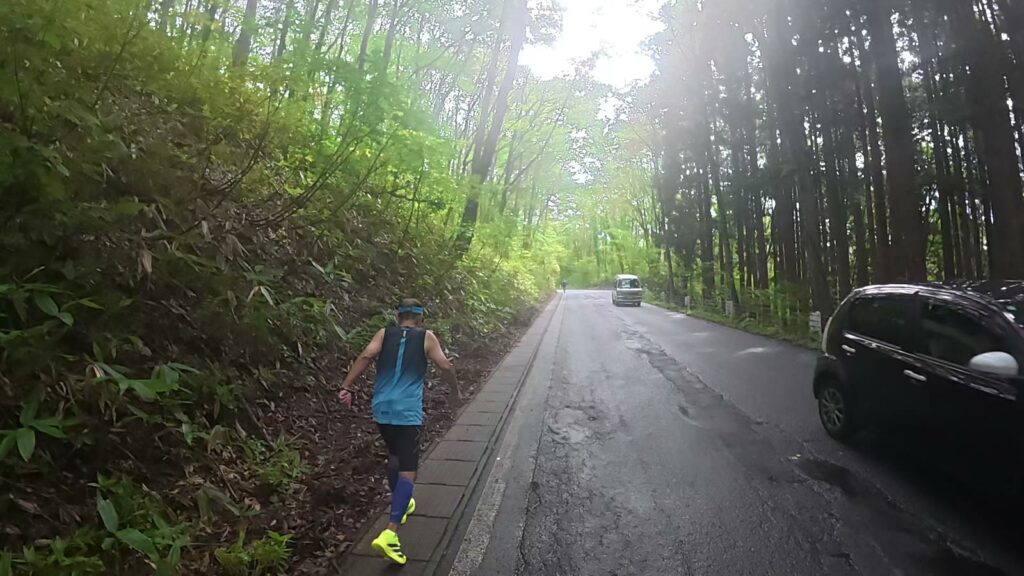 森の中の坂道を上るランナー（田沢湖マラソン36km付近）