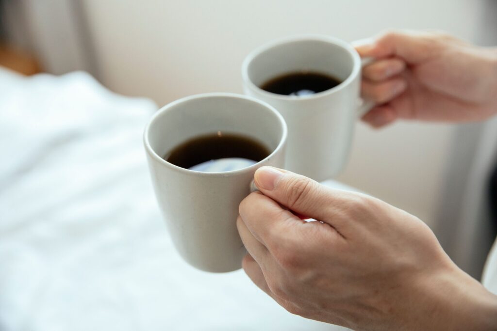 2つのマグカップのコーヒーで乾杯しているところ